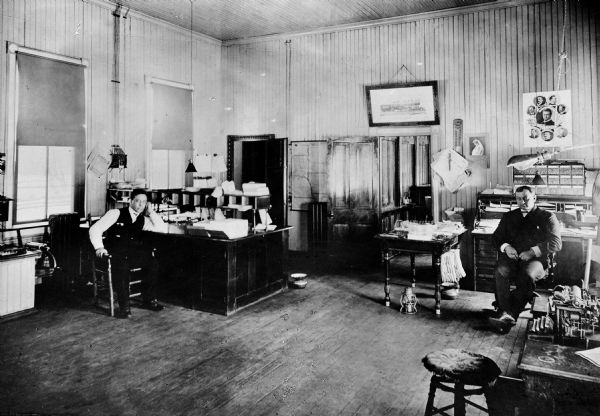 Superintendent J.N. Harrison and dispatcher W.H. Wright are seated at desks in the Wisconsin & Michigan Railroad office.
