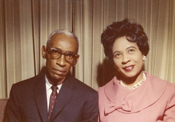 Informal portrait of Daisy and L.C. Bates seated in front of a curtain.