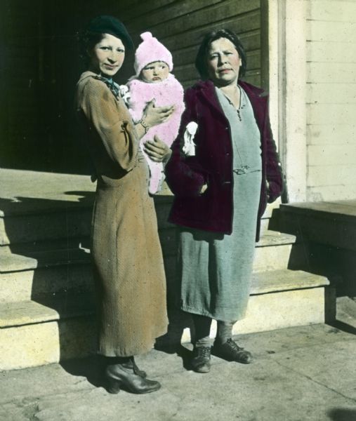 Two women and an infant represent three generations of an Indian family. They are posing at the steps of the Health Center, where they are to attend Mothers' classes.