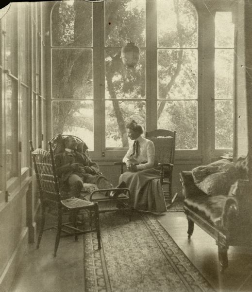 Two members of the Dousman Family relaxing on the porch of Villa Louis.