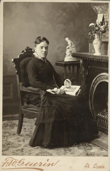 Seated full-length portrait of the "French governess for the Dousman family children." On the back of the cabinet card: the imprint of F.W. Guerin, Photographer, Cor. 12th and Washington Ave, St Louis, and a hand-printed name: "M. Leocadi"