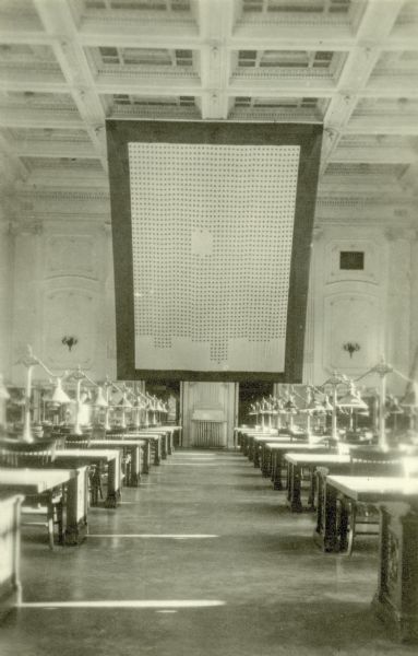 The large service flag that honored all University of Wisconsin students who served during World War I on display in the Reading Room. The students themselves created the flag which consisted of 1,750 blue stenciled stars, each embroidered with the name of an individual. It was first displayed in Bascom Hall on Decoration Day, 1918. The flag was then taken down and displayed in the Historical Society Library, then also the Library of the University.