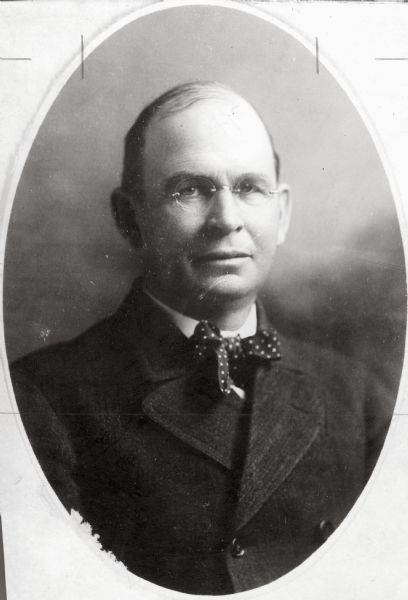 Quarter-length studio portrait of Walter Houser, wearing a polka-dotted bow tie.