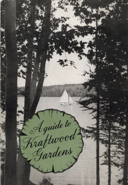 Cover of <i>A guide to Kraftwood Gardens</i> showing a view of a sailboat on Lake Machkinosiew (now Enterprise Lake) seen between trees. The publication's title is printed on a design element resembling a cross section of a tree.