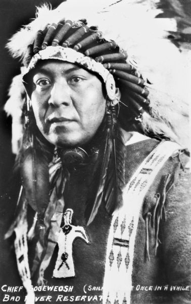 Bad River Ojibwa Chief Gogeweosh (<i>Sailing Home Once in a While</i>). Chief Gogeweosh is wearing a feather war bonnet and a buckskin shirt with a beaded thunderbird on the front.