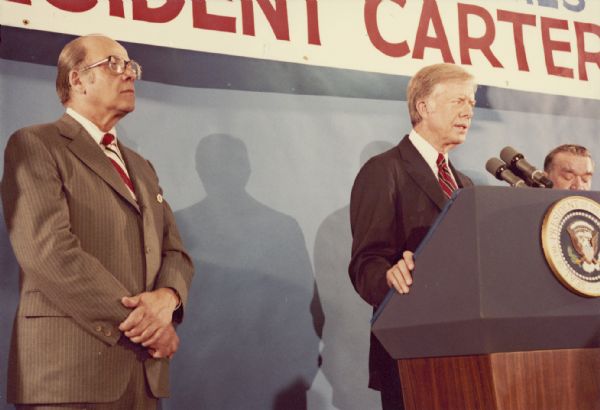 President Jimmy Carter speaking at a podium during the Wisconsin State American Federation of Labor and Congress of Industrial Organizations 11th biennial convention.