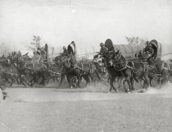 Soldiers at Camp Douglas driving horses and covered wagons.