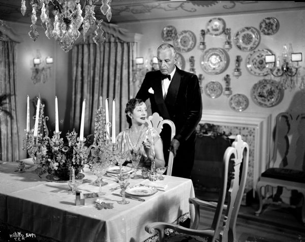 Alfred Lunt and Lynn Fontanne formally dressed in the dining room of their home, Ten Chimneys.