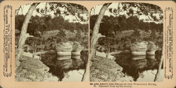 An elevated upstream view of the rock formation in the Wisconsin River known as the Ink Stand. Text at right: "Wanderings Among the Wonders and Beauties of Wisconsin Scenery."