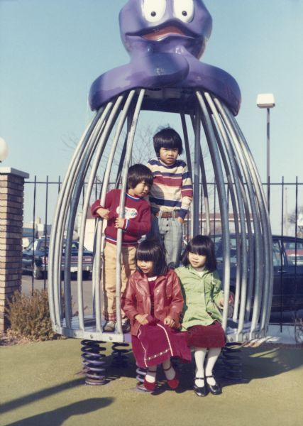 The children of Trong and Hong Nguyen pose on a playground structure shaped to look like the McDonald's character <i>The Grimace</i>. From left to right in back are Charlie Nguyen and Minh Nguyen. Seated from left to right in front are Thuy Nguyen and Mary Nguyen.
