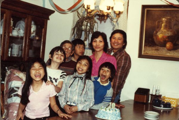 The Nguyen family and a friend pose together at home as they celebrate Thuy Nguyen's 10th birthday. From left to right in front are: Mary, Thuy (in a blue shirt) and Charlie Nguyen. Behind them from left to right are family friend Megan Dymzarov, grandfather Kim, Minh, Hong and Trong Nguyen.
