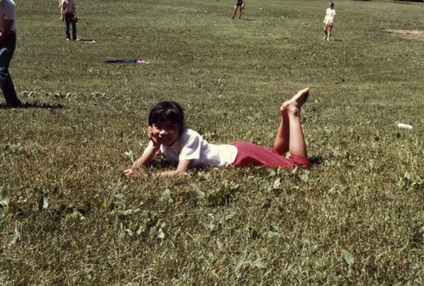 Thuy Nguyen lays on the grass in a park on a sunny day.