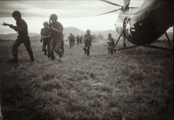 Marines running out of a helicopter in Vietnam.