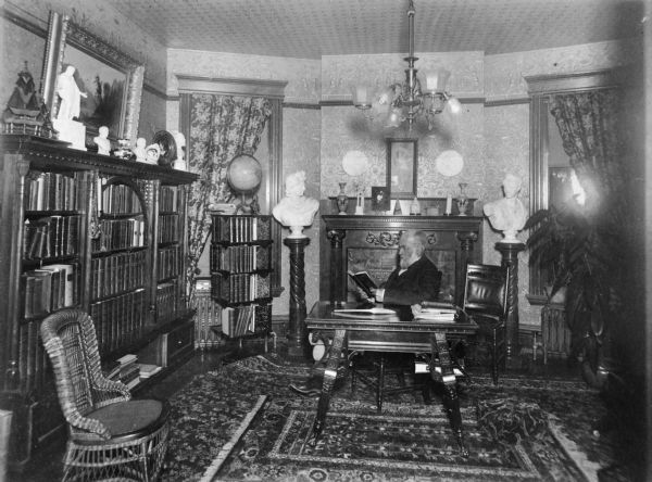Halle Steensland poses in his lavishly decorated library at his house on 315 North Carroll Street.