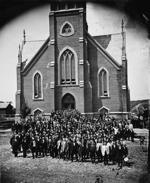 First Norwegian Lutheran Church with congregation posed outside the front entrance, part of a set of stereographs entitled "The Synod at Decorah, 1876" from Dahl's 1877 "Catalog of Stereoscopic Views."