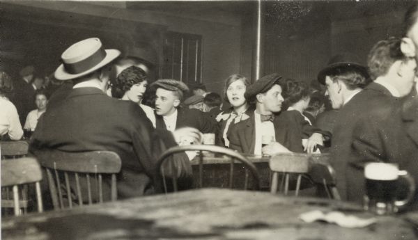 People sitting at tables, drinking and talking at 2 a.m. in one of two wine rooms at the South Side Kindergarten Hall, 396 Greenbush Street.