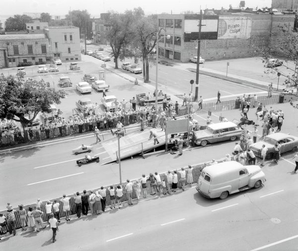 Elevated view of the starting ramp for the Madison Soap Box Derby on East Washington Avenue, including the first block of South Butler Street. Van Steiner in the Phillipson Garage car, the eventual winner of both the Madison and the national races, is even with his competition at this point.