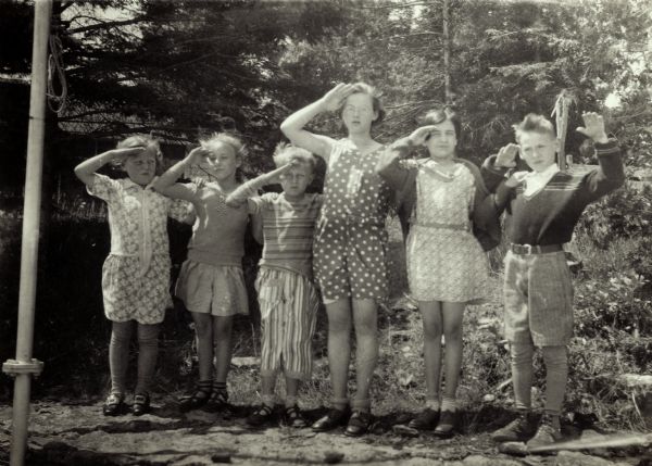 Georgette Louise (Dickey) Meyer, the tall, bespectacled girl in the middle, salutes with five other children.