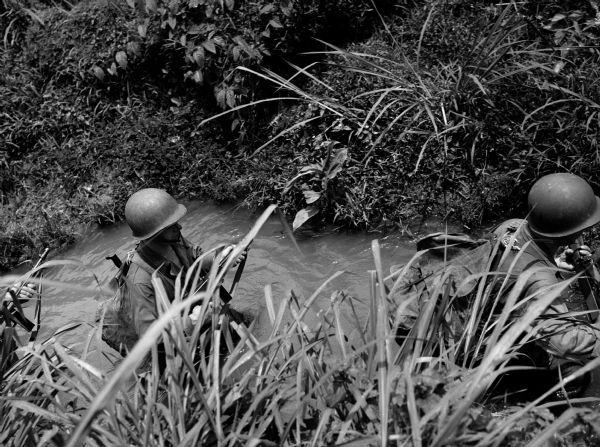Elevated view of soldiers fording a stream in Panama.