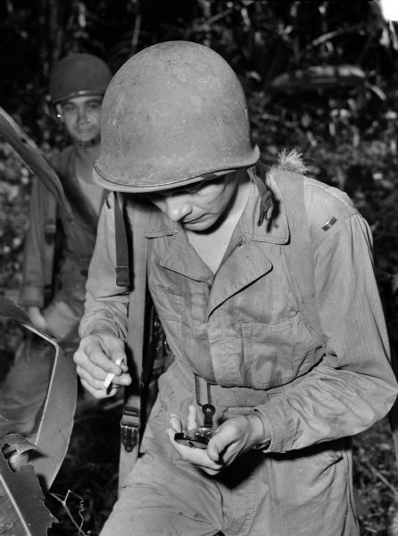A patrol officer looks at his compass as he smokes a cigarette.