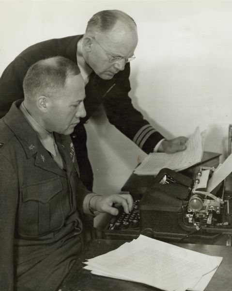 Colonel Robert S. Allen, a well-known journalist before World War II, lost his arm while on active duty in Europe. He is seated here with Dr Anton Dvorak, the inventor of a one-arm typewriter that permitted him to resume his career despite his handicap.