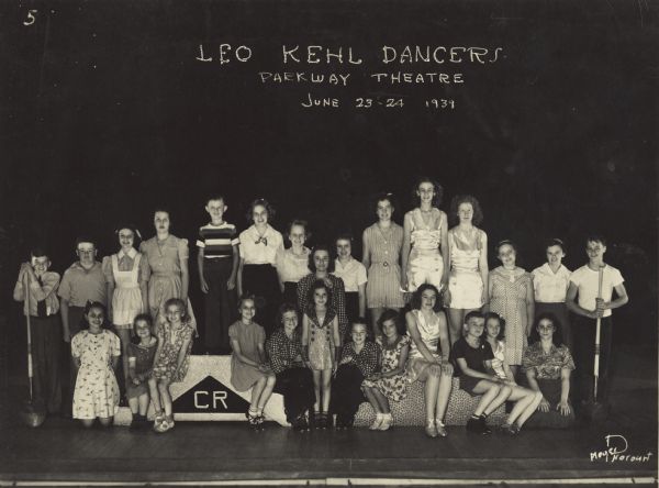 Group portrait of the Leo Kehl Dancers commemorating their recital at the Parkway Theater on June 23rd and 24th. 

In the first row from left to right are Patsy Ruth Schoenmann, Genevefa Pirola, Barbara Jane Kehl, Carol Bjelde, Jean (?) Heim, Jacquelyn (?) Stafford, Corrine (?) Schmitz, Gloria Green, Marion Green, Dicky Hanchete, Marion Hogues, and Phyllis Sweet. In the second row from left to right are Skippy Kehl, Clyde Hebervein, Elaine Johnson, Polly Ann Schoenmann, Charles Redel, Nina Mae Miller, Lily Mae Hoffman, Jean (?) Meuer, Mary Jane Kelly, Mildred Kehl, Dorothy Durlin, Ardyth Eldredge, Muriel Sweet, Betty Johnson and John Duckwitz.
