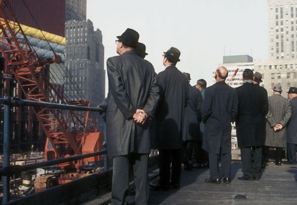 Rear view of onlookers observing the construction of the World Trade Center towers.