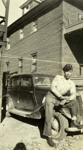 Lewis Arms poses with his foot on the bumper of his 1936 Studebaker automobile.