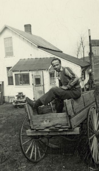 Lewis Arms sits on a wagon at Bernard Arms's farm.