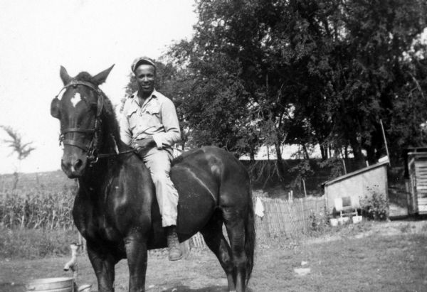 Lewis Arms sits on the back of a horse, probably on his uncle Bernard Arms's farm.