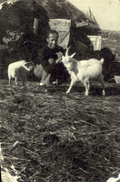 Lewis Arms poses with a goat and a dog on Otis Arms's farm.