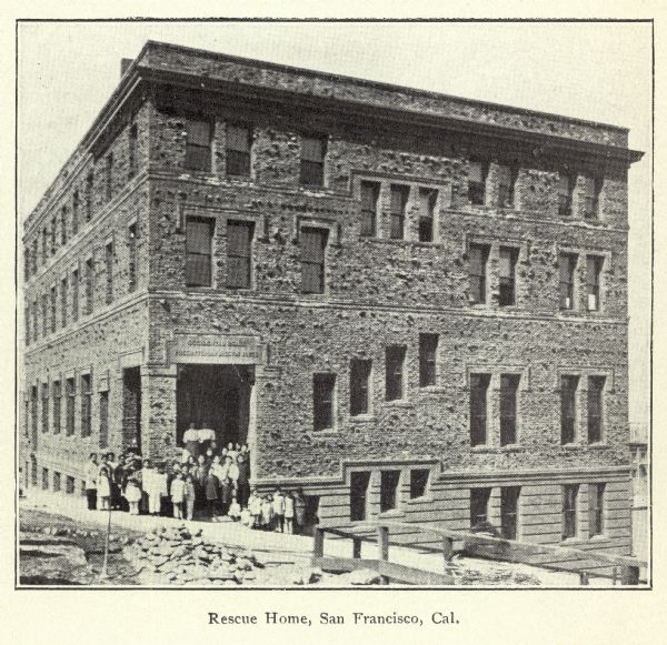 Exterior view of the Cameron Mission, a home for rescued Asian (Chinese and Japanese) slaves in San Francisco. Some of the residents are posed in a group at the entrance.