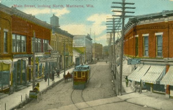 Colorized elevated view looking north down Main Street. There is a streetcar and two horse-drawn vehicles in the foreground. Caption reads: "Main Street, looking North, Marinette, Wis."