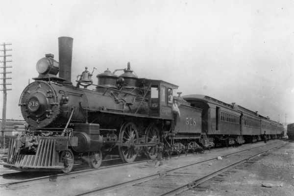 View of locomotive engine no. 518 on the Chicago, Milwaukee and St. Paul railroad. Two men are posing on the train.