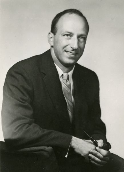 Studio portrait of Leslie H. Fishel, Jr., holding a pipe. He was the Director of the State Historical Society of Wisconsin from 1959 until 1969.
