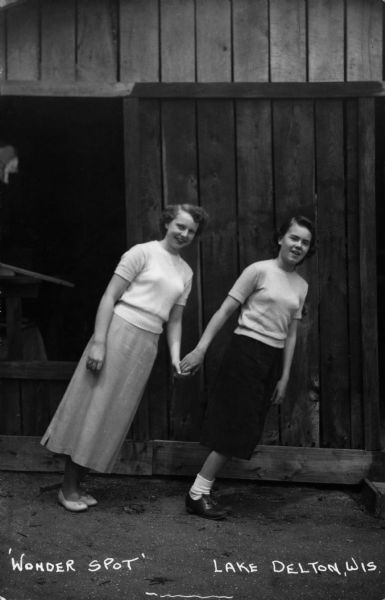 Two women hold hands while demonstrating the visual characteristics of the Wonder Spot. Caption reads: "The Wonder Spot, Lake Delton, Wis."
