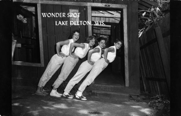 Four women demonstrate the visual characteristics apparent at the Wonder Spot. Caption reads: "Wonder Spot, Lake Delton, Wis."
