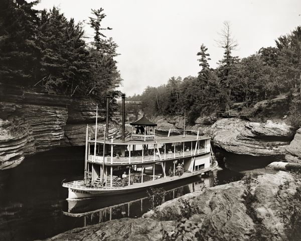 "Apollo No. 1" steamboat entering Devil's Elbow at Narrows. There is a building in the background with a sign on the roof, probably the Larks Hotel.