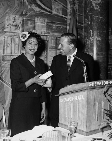 The Honorable John D. Brown, Director of Public Celebrations for the City of Boston, presents Daisy Bates with a replica of the famed "Paul Revere Bowl" at a breakfast given in Bates' honor by Mayor John B. Hynes.