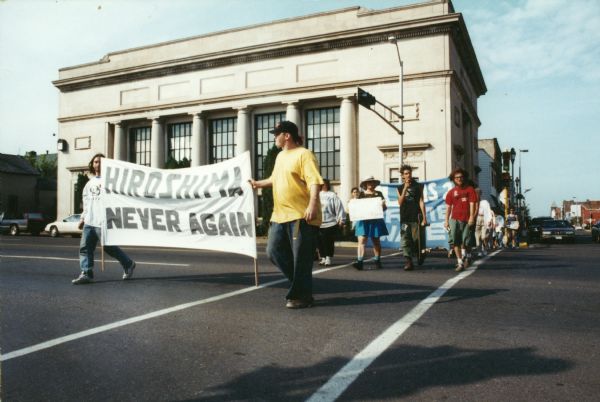 Group of people walking across road during a Nukewatch peace march.