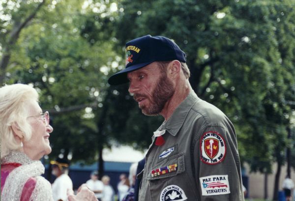 David Cline, a Vietnam War veteran and a national leader in Vietnam Veterans Against the War and Veterans for Peace, talking to a woman at a Memorial Day ceremony in Jersey City.
