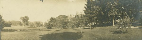 Panoramic view of southwest corner of Villa Louis lawn. The house and a path can be seen at right.