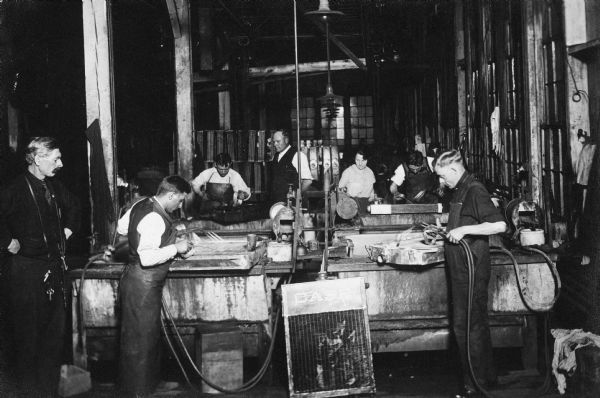View of a group of men in a workshop learning to repair radiators for a war training class.