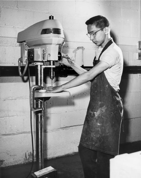 A student at the Milwaukee Vocational and Adult Schools operates a drill press.