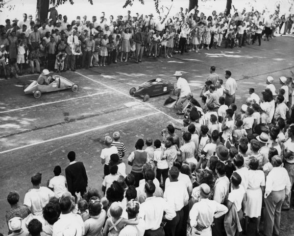 Paul R. Anderson of DeForest winning the final heat of the 1946 Madison soap box derby in his car the "Green Hornet."  The race was held on Gorham street.  Paul went on to compete at the All-American Soap Box Derby in Akron, Ohio.  

Shows elevated view of crowd and the "Green Hornet" crossing the finish line.