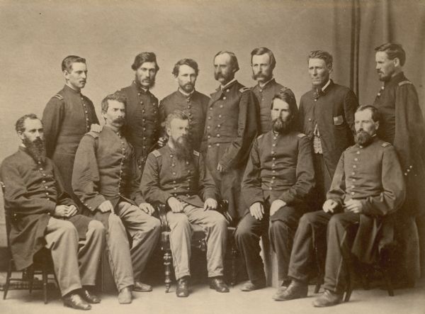 Officers of the 43rd Wisconsin Volunteer Infantry, with Colonel Amasa Cobb seated at the center. It is likely this picture was taken when the field and staff were mustered out in Nashville, Tennessee, in June, 1865. Cobb had been colonel of the 5th Wisconsin, which he resigned upon election to Congress. As a result he was absent from the 43rd when Congress was in session and during an appointment to brigade command, but returned to be with the regiment in Nashville when the field and staff were mustered out in June, 1865.  It is likely this photograph was taken at that time, for Lt. Colonel Byron Paine who was command of the regiment during most of its service, is not in the photograph. He had resigned several weeks earlier because of family bereavement. Of the others in the picture only Major Samuel S. Brightman, in the double-breasted uniform behind Cobb, can be definitely identified. The man to Cobb's immediate left is thought to be Surgeon C.C. Hayes. The man not wearing a uniform may be the chaplain, John Walworth.