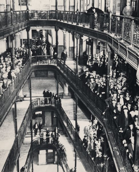 View of the atrium of Milwaukee's City Hall with a crowd of people gathered to register for unemployment compensation.