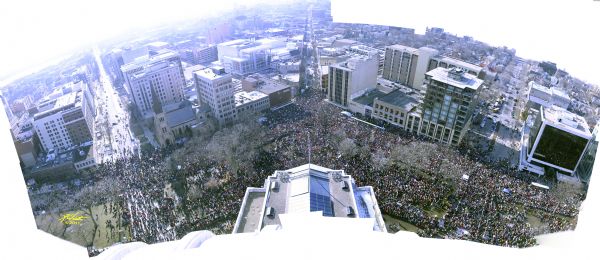 Photographic collage taken from the top of the Wisconsin State Capitol building. It shows an area filled with thousands of protesters from West Washington Avenue past State Street and beyond Wisconsin Avenue.