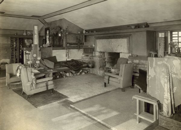 Living room of Taliesin II looking towards the fireplace, built-in bench, and work storage area.