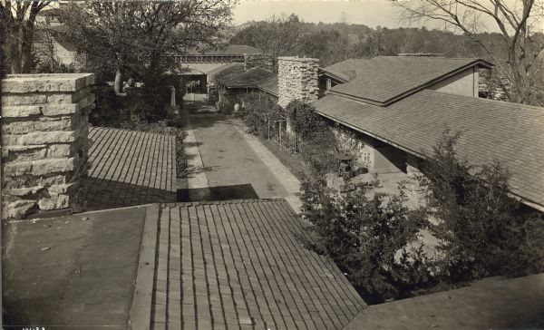 Elevated view looking northwest into the courtyard of the Taliesin II from the roof of the residence. The reconfigured roof of the studio space as well as new gates between the the courtyard and the barn yard are visible in this image. Two horses are standing behind the gate.
